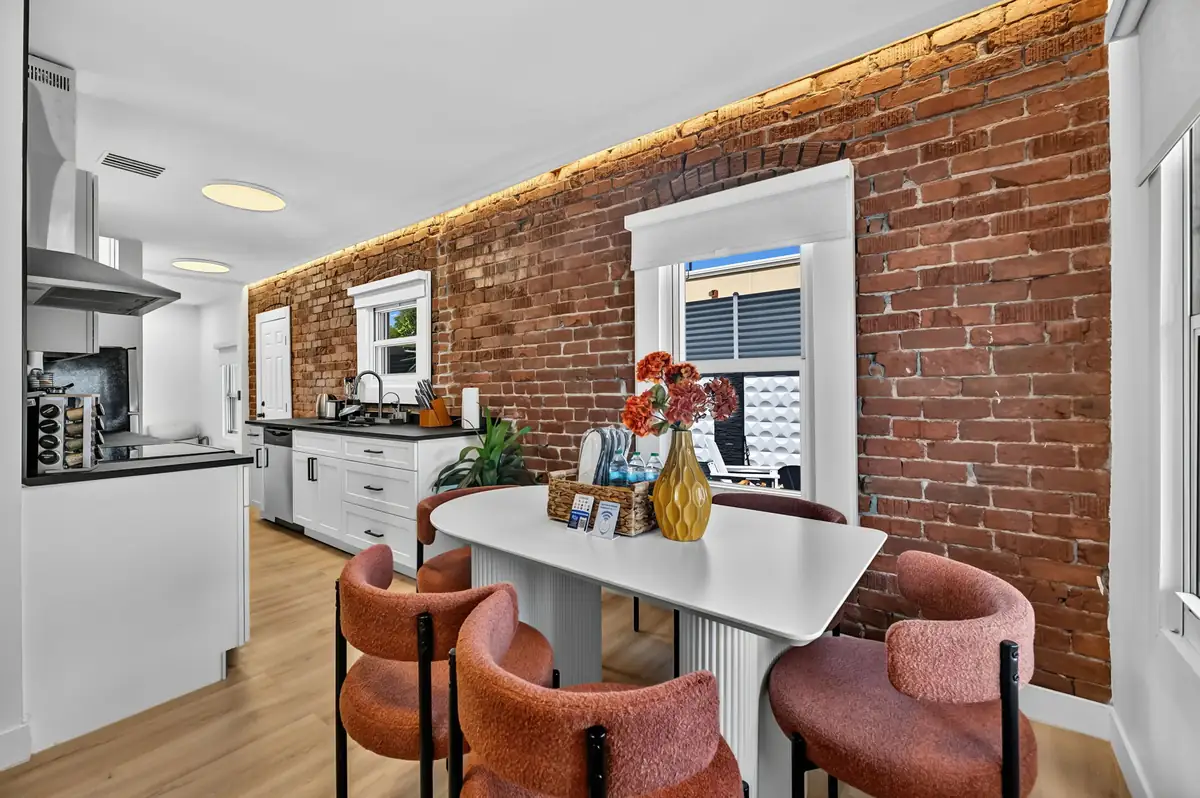 Elara dining and kitchen with exposed brick